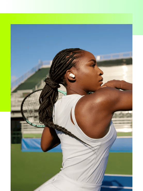 Coco Gauff wearing Bose QuietComfort Earbuds II on a tennis court