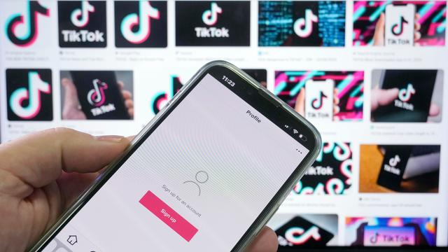 TikTok-App auf einem Smartphone vor Werbe-Screens in Sydney, Australien