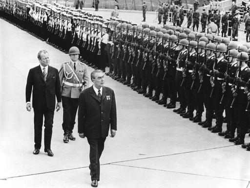 Willy Brandt (l.) und Leonid Breschnew. Zwei ältere Männer laufen eine Militärparade ab.