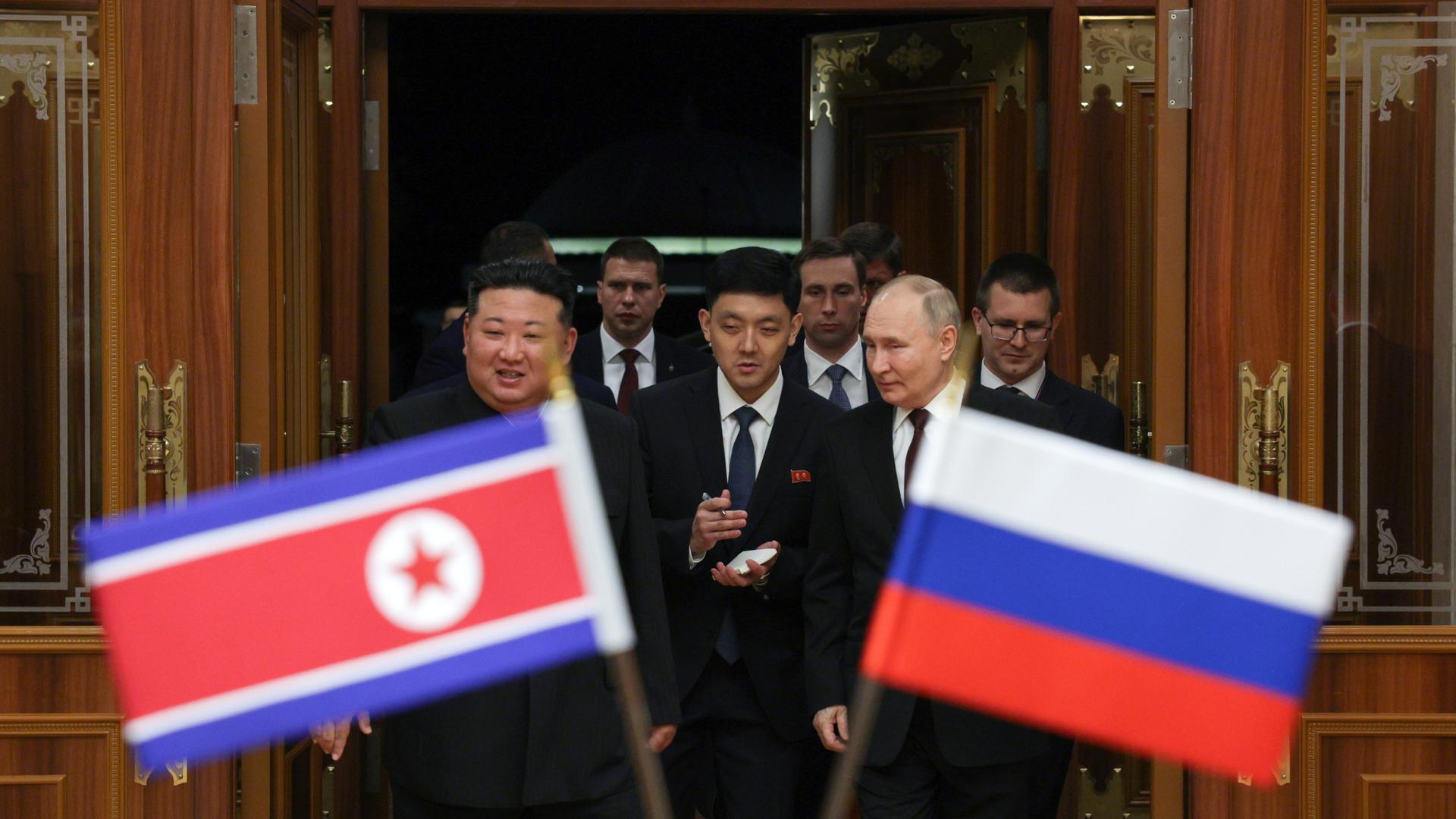 Wladimir Putin trifft Kim Jong Un in Nordkorea, die Flaggen beider Staaaten sind zu sehen.