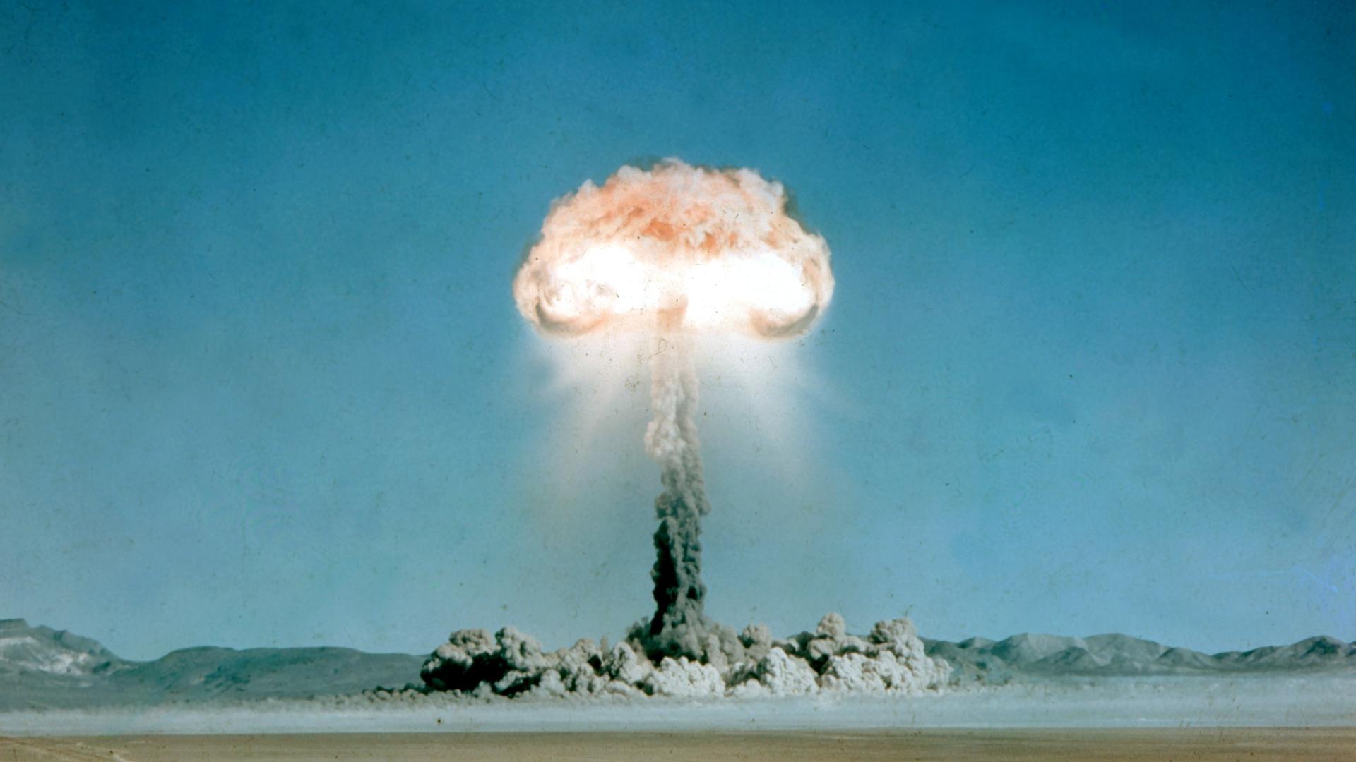 Ein Atompilz steigt nach der Explosion einer Atombombe über dem Testgelände in der Wüste von Nevada auf.