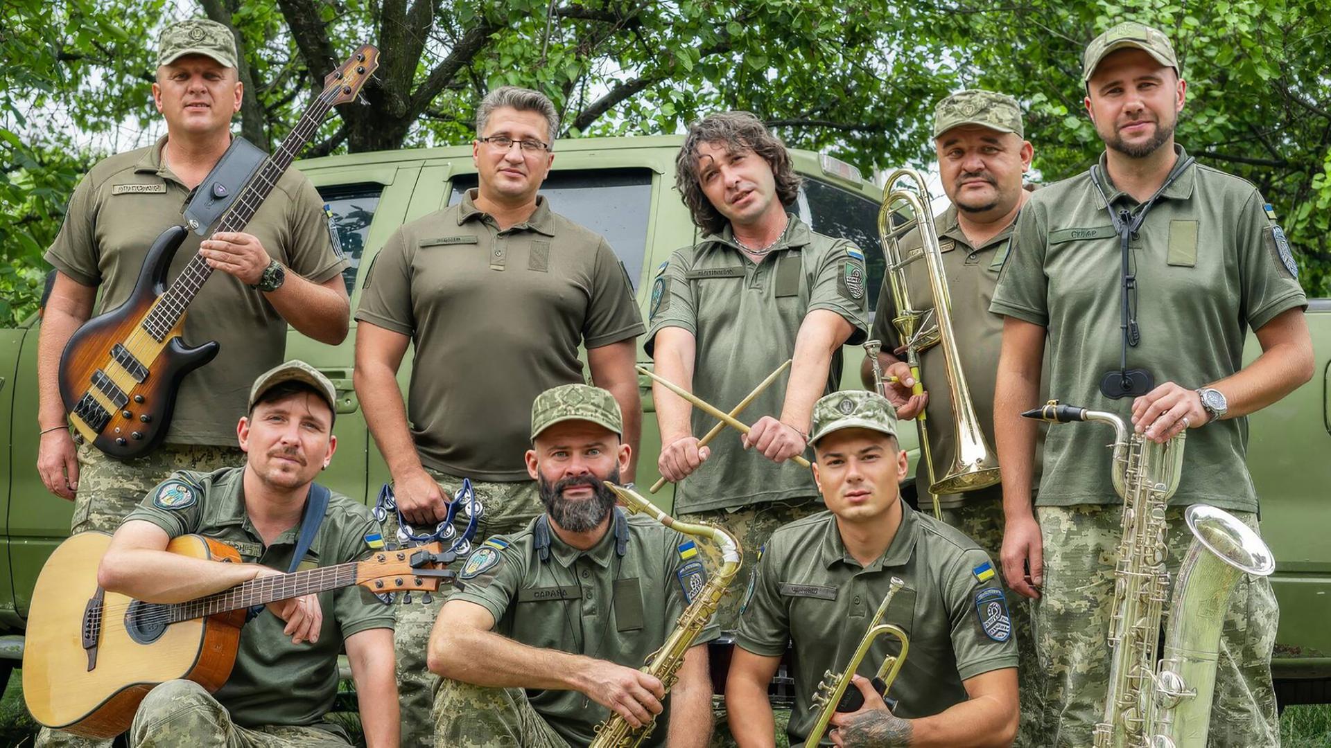 Acht Musiker des "Cultural Forces" Orchesters mit ihren Instrumenten in Uniform.