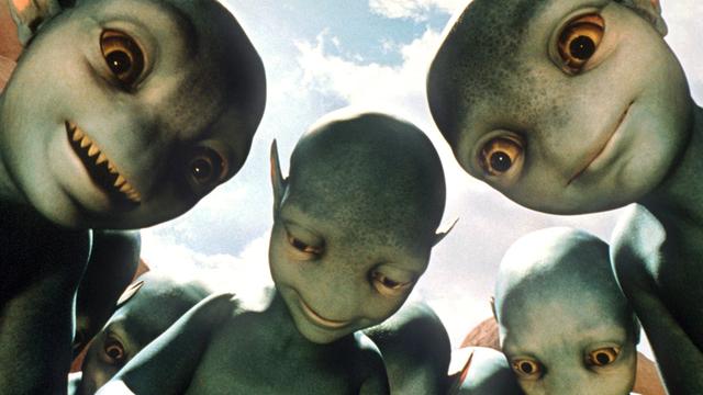 Feindlich gesinnte Aliens beäugen im Kinofilm "Galaxy Quest - Planlos durchs Weltall" (Szenenfoto) auf einem real existierenden fernen Planeten menschliche Besucher.