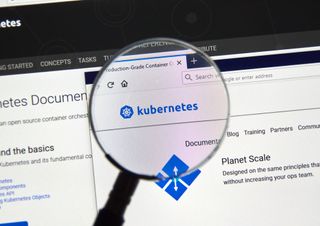 A magnifying glass held over a kubernetes logo on a computer screen