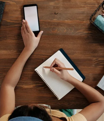 overhead shot of someone writing on table