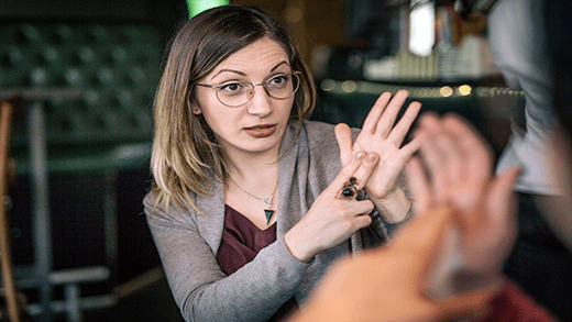 Deux femmes prenant un café en utilisant la langue des signes comme moyen de communication.