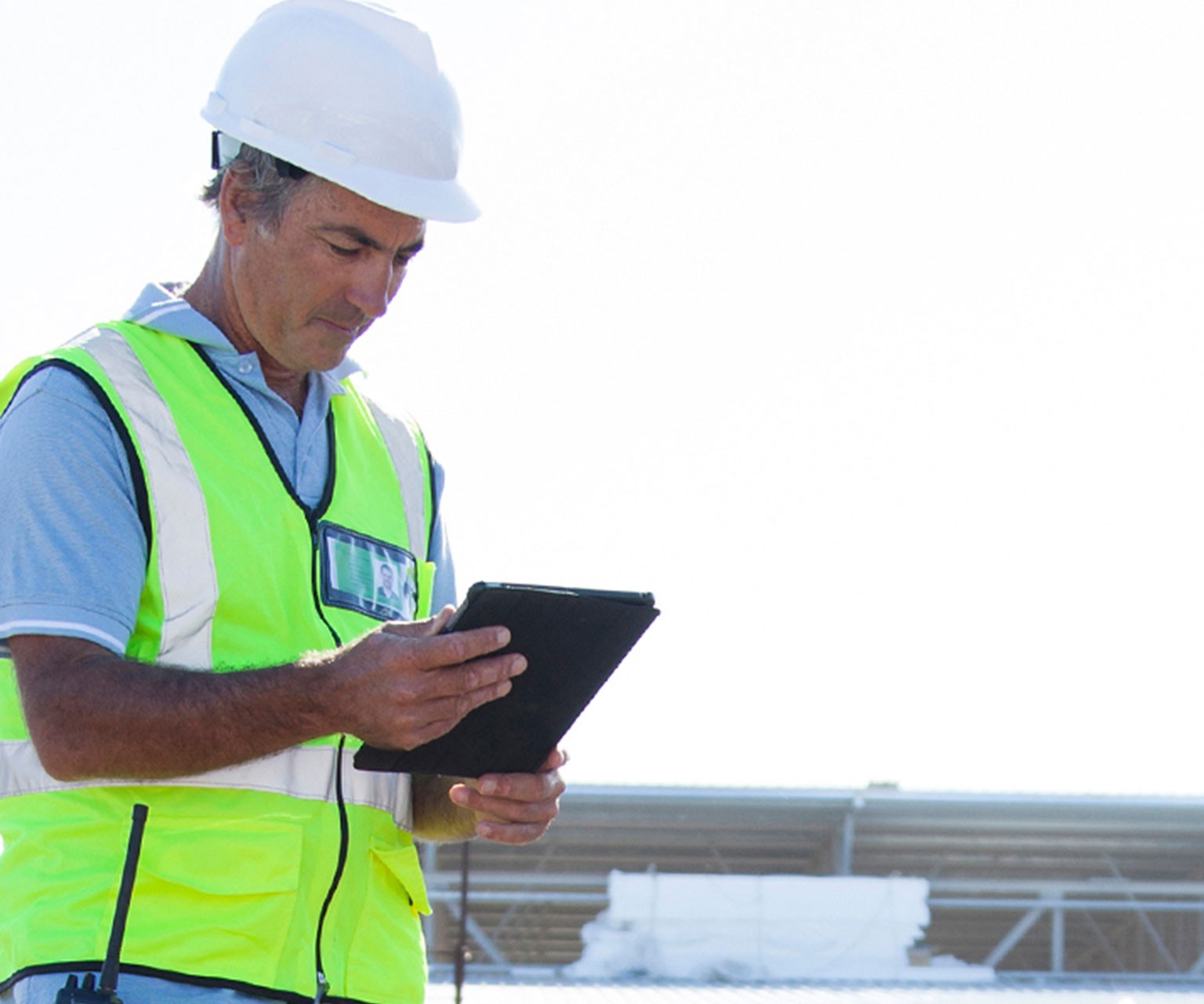 Man using a tablet while standing outside at a construction job site