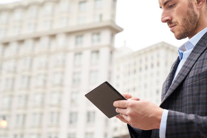 a white business man looking at a tablet in the city