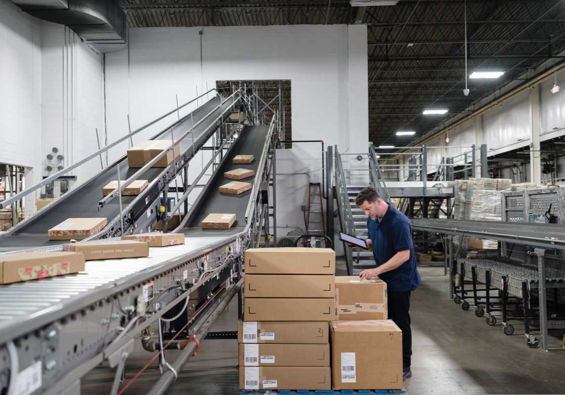 man in warehouse checking packages