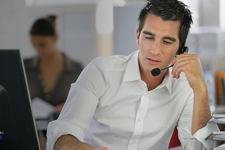 Young man telemarketer in call center