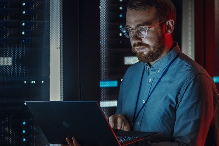 Man using laptop while working in server room