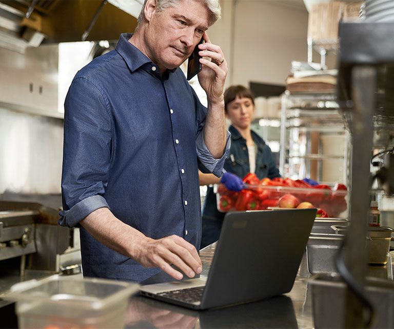 Tate and Lyle man using computer in kitchen