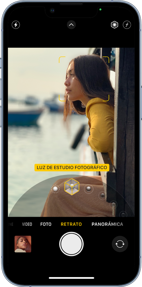 La pantalla de la app Cámara el modo Retrato; en el visor, el objeto se muestra nítido y el fondo difuminado. El selector de efectos de iluminación de retrato está abierto debajo del cuadro y el efecto Luz de estudio fotográfico está seleccionado. En la parte superior izquierda de la pantalla se encuentra el botón Flash; en la superior central, el botón Controles de cámara; y, en la superior derecha, los botones para ajustar la intensidad de la iluminación de retrato y el control de profundidad. En la parte inferior de la pantalla, de izquierda a derecha, se encuentran los botones Visor de fotos y videos, Tomar foto y Selector de cámara posterior.