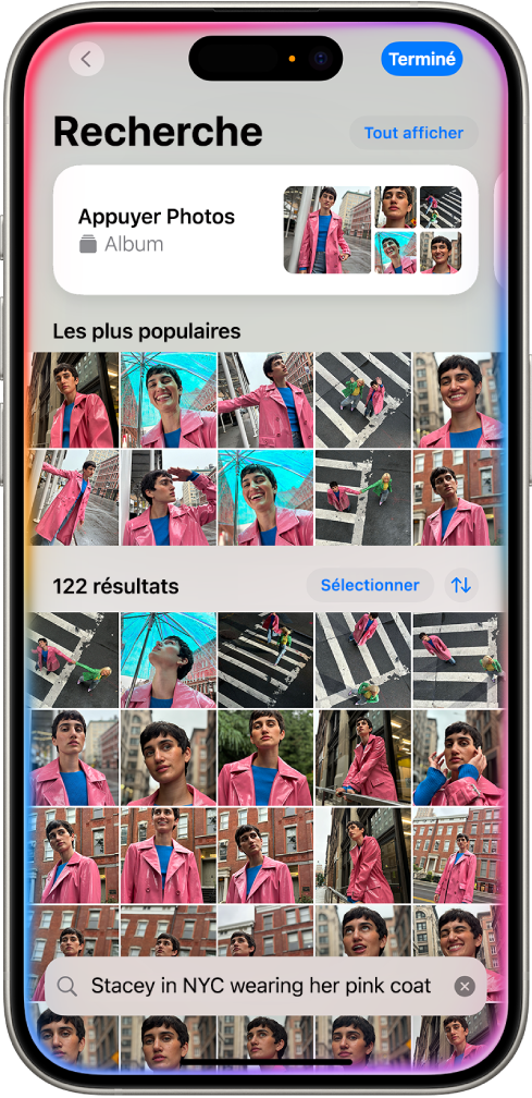 iPhone affichant des photos dans l’app Photos. Une barre de recherche avec une description s’affiche en bas de l’écran.