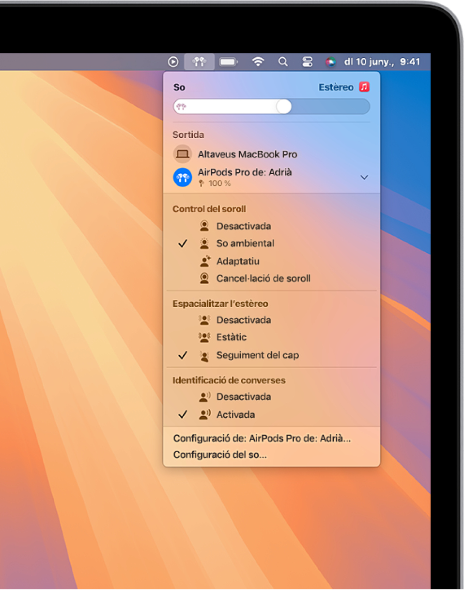 Pantalla del MacBook Pro amb una cançó que s’està reproduint a l’app Música. A la barra de menús, la icona dels AirPods està seleccionada i un menú mostra els AirPods amb la cancel·lació de soroll i el seguiment del cap de l’àudio espacial activats.