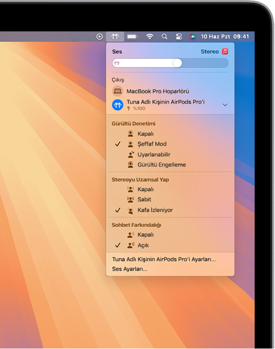 Müzik uygulamasında çalan bir parça ile bir MacBook Pro ekranı. Menü çubuğunda, AirPods simgesi seçili ve bir menüde gürültü engelleme ve kafa izlenmiş Uzamsal Ses açık olan AirPods gösteriliyor.