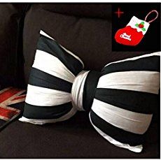 a black and white striped bow tie sitting on top of a couch next to pillows