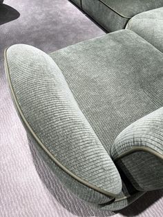 a grey couch sitting on top of a carpet covered floor