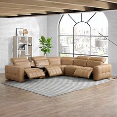 a living room with a large sectional couch in front of a window and a rug on the floor