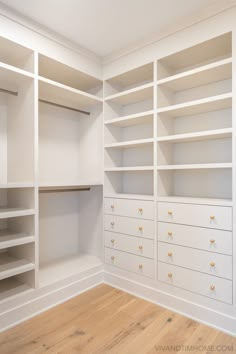 an empty closet with white shelving and wood flooring is pictured in this image