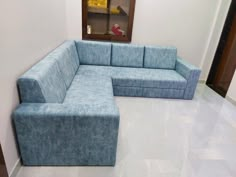 a blue couch sitting on top of a white tiled floor