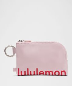 a pink purse with the word lululemon on it and a keychain