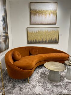 an orange curved couch sitting on top of a rug