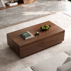 a coffee table that has some fruit on it and a book in front of it