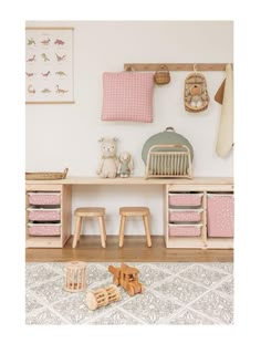 a toy room with wooden toys on the floor and pink accessories hanging from the wall