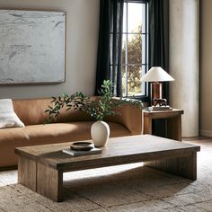 a living room with a couch, coffee table and large painting hanging on the wall