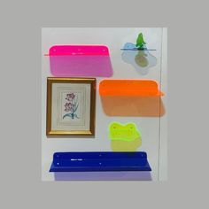 INCLUDES - 1x 12in wide UV reactive transparent neon pink round edge rectangle acrylic shelf  - 1x 12in wide UV reactive transparent neon orange round edge rectangle acrylic shelf - 1x 19in wide UV reactive transparent royal blue round edge rectangle with lip acrylic shelf   - 1x 6in wide UV reactive neon green transparent irregularly shaped flower acrylic shelf  - 1x 6in wide UV reactive neon blue transparent acrylic "pond" shelf  -1x 2in wide translucent dark green frog standing on lily pad fi Frog Standing, Acrylic Wall Shelf, Art Studio Inspiration, Flower Acrylic, Acrylic Shelf, Pink Round, Studio Inspiration, Uv Reactive, Green Frog