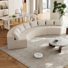 a living room filled with furniture and a large white sectional couch on top of a wooden floor