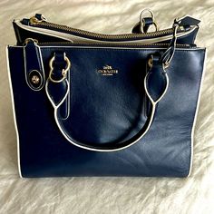 This Vintage Deep Navy Leather Coach Handbag Is The Ultimate Statement Piece With Its Clean Lines And Cream Piping Detail. It Features Two Handles And Two Gold Toggles To Secure Side Zippers. In Addition To The Two Side Zipper Compartments, There Is One Zipper Compartment And Two Open Pockets Within The Bag. This Item Is In Excellent Condition And At A Fraction Of What It Normally Retails. Coach Vintage Handbags, Vintage Handbag, Coach Handbag, Leather Coach, Bags Coach, Navy Leather, Vintage Coach, Coach Handbags, Coach Bags