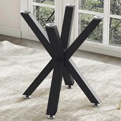 a black and silver table with four legs in front of a white carpeted floor