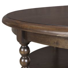 a close up of a wooden table with an oval top and two small round legs