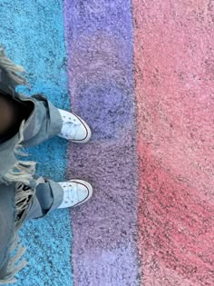 a person standing in front of a multi colored rug with their feet on the ground