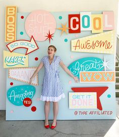 a woman standing in front of a wall with signs on it