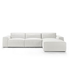 a white couch sitting on top of a white floor next to a chair and ottoman