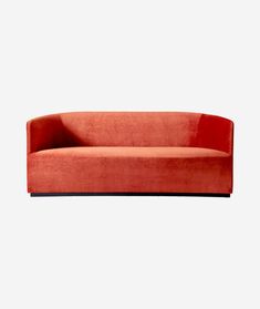 an orange couch sitting on top of a white wall