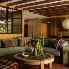 a living room filled with furniture and wooden walls