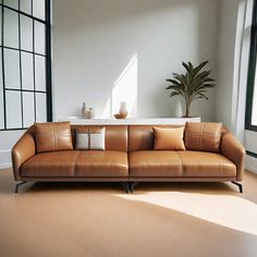 a brown leather couch sitting on top of a hard wood floor next to a window