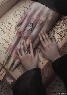 two hands holding each other over an open book with writing on the pages behind them