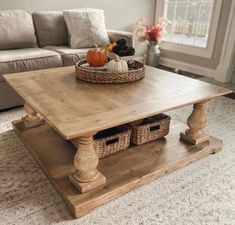 a living room with a couch, coffee table and two baskets on top of it