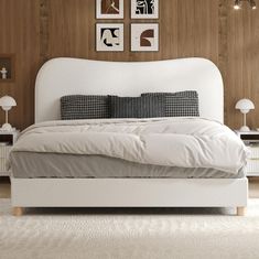 a white bed sitting in a bedroom on top of a hard wood floor next to a wall