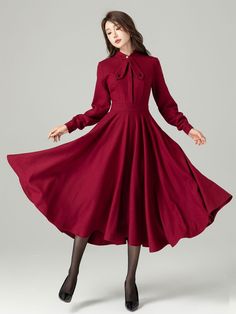 "Red long sleeve wool swing dress featuring a delightful bow tie. The flared silhouette adds movement and charm, while the premium wool fabric offers both comfort and quality. The bow tie serves as a chic accessory, enhancing the overall look. Whether you're attending a formal event or a festive gathering, this red long sleeve wool swing dress will make you stand out with its timeless design. Details: * 30% wool, 30% fiber, 40% polyester * fully satiny lining, more nice to the touch body * Invisible Front buttons, right zipper closed * Two seam pockets * long sleeve, button closure on the cuff * Fitted waist, flared dress * Perfect for Spring,autumn, winter * Plaid wool dress with same style: https://etsy.me/3Pb3Aaq MODEL SIZE Bust 85 cm(33.4\")  Waist 67 cm(26.7\")  Height 168cm (5' 6\") Modest Dresses Casual Winter, Burgundy Dress Outfit Casual, Princess Winter Dress, Romantic Casual Outfit, Red Coat Dress, Warm Dress, Classic Timeless Style, Fashion Sketches Dresses, Korean Fashion Dress