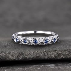 a white gold wedding band with blue sapphires on top and diamonds in the middle