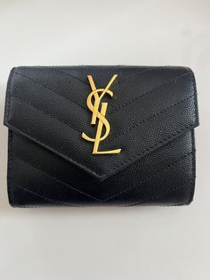 Like new condition! Used only twice! Saint Laurent wallet in chevron-quilted powder-grain calf leather with signature YSL monogram at center with overstitching Envelope flap with snap closure Golden hardware Interior, one bill and six card slots Four slip pockets; zip coin slot 3.9"H x 4.9"W x 1"D Made in Italy Coin Slot, Saint Laurent Wallet, Trifold Wallet, Tri Fold, Snap Closure, Calf Leather, Card Slots, Slots, Women's Accessories