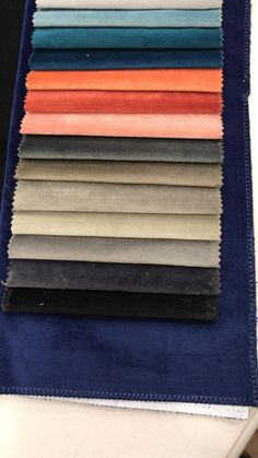 several different colors of fabric laid out on top of each other, including blue and orange