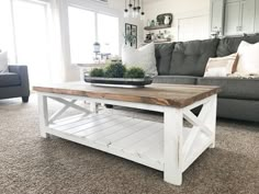 a living room with a gray couch and white coffee table