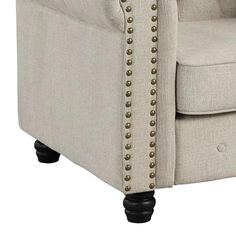 a beige chair with studded arms and legs